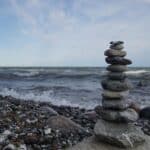 Stacked stone cairn by the sea, why stone urns feel timeless, cremation service Ballwin, MO