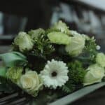 Funeral car with rose bouquet on hood, transport request steps, cremation service St. Louis, MO