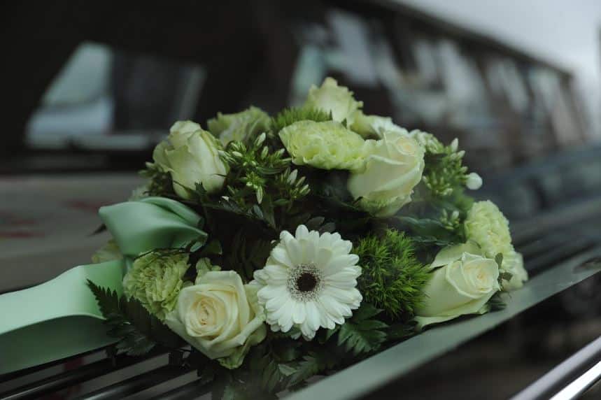 Funeral car with rose bouquet on hood, transport request steps, cremation service St. Louis, MO